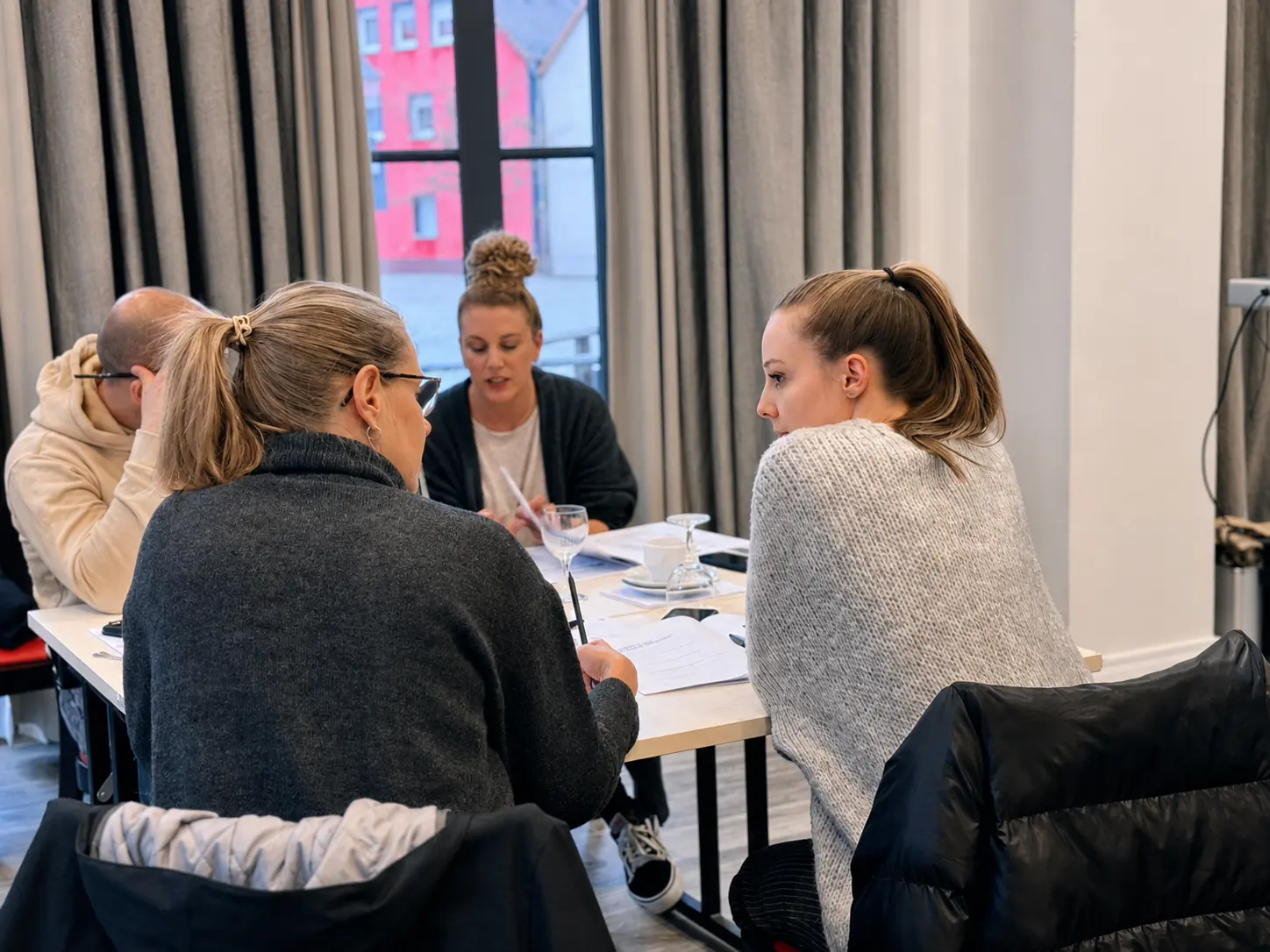 Teilnehmende arbeiten in einer konzentrierten Trainingssituation gemeinsam an ihren Aufgaben